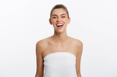 Temiz cilt, doğal makyaj ve gri arka plan üzerinde beyaz dişler güzel gülümseyen kız