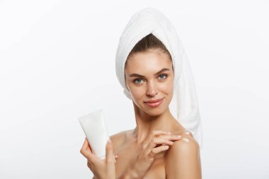 Beyaz bir arka plan üzerinde omuz krem uygulayarak kadın.