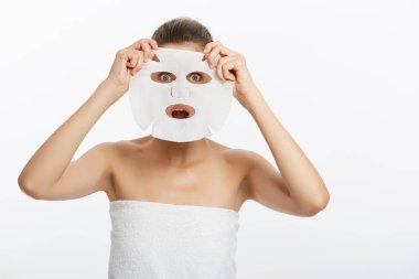 Güzellik cilt bakım kavramı - güzel beyaz kadın uygulanan kağıt levha maske onun yüz beyaz arka plan üzerinde.