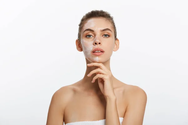 Close up of a woman with cosmetic facial mask applied over her face looking away. — Stock Photo, Image