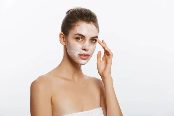 Primo piano di una donna con maschera cosmetica per il viso applicata sul suo viso guardando altrove . — Foto Stock