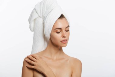 Spa ve güzellik kavramı - mutlu genç kız temiz cilt ve kafasındaki beyaz bir havlu ile yüzünü yıkar.