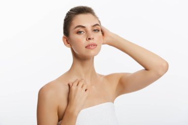 Pürüzsüz cilt doğal makyaj ile hafif bir arka plan üzerinde güzel genç kızla.