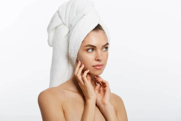 Spa- och skönhetscentret koncept - glad ung flicka med ren hud och med en vit handduk på huvudet tvättar ansiktet — Stockfoto