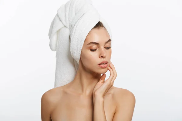 Spa- och skönhetscentret koncept - glad ung flicka med ren hud och med en vit handduk på huvudet tvättar ansiktet — Stockfoto