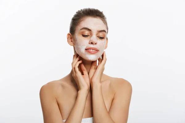 Primer plano de una mujer con máscara facial cosmética aplicada sobre su cara mirando hacia otro lado . — Foto de Stock