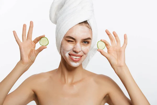 Retrato de beleza de mulher sorridente com toalha na cabeça e fatia de pepino na mão isolado em fundo branco . — Fotografia de Stock