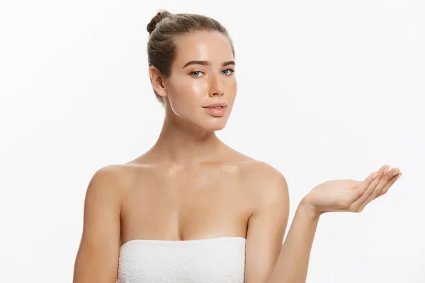 Belleza de piel y mujer spa envuelto en toalla que muestra copyspace con la mano presente en el lado. Aislado sobre blanco . — Foto de Stock