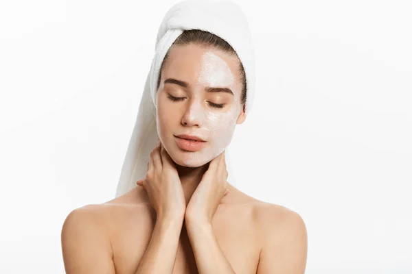Junge Frau mit Gesichtsmaske aus Ton, isoliert auf weiß — Stockfoto
