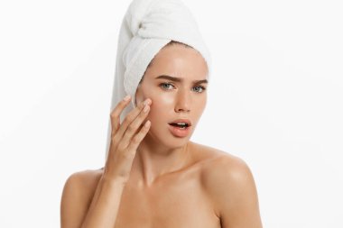 Genç kadın bir sivilce bir yanağına bulma. Beyaz arka plan üzerinde izole