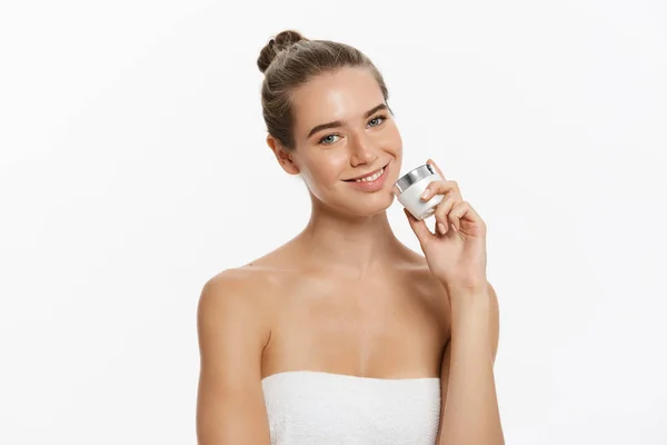 Beauty Youth Skin Care Concept - Beautiful Caucasian Woman Face Portrait holding and presenting cream tube product. Beautiful Spa model Girl with Perfect Fresh Clean Skin over white background