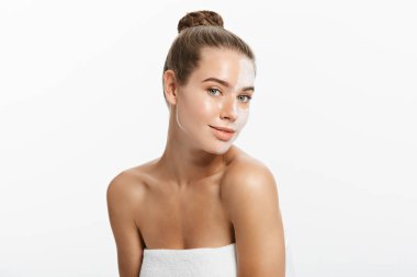 Yüzünün yarısına krem sürmüş, beyaz tenli bir kadın.