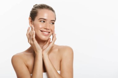 Temiz cilt, doğal makyaj ve gri arka plan üzerinde beyaz dişler güzel gülümseyen kız.