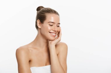 Temiz cilt, doğal makyaj ve gri arka plan üzerinde beyaz dişler güzel gülümseyen kız.