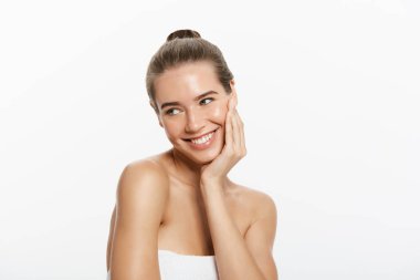 Temiz cilt, doğal makyaj ve gri arka plan üzerinde beyaz dişler güzel gülümseyen kız.