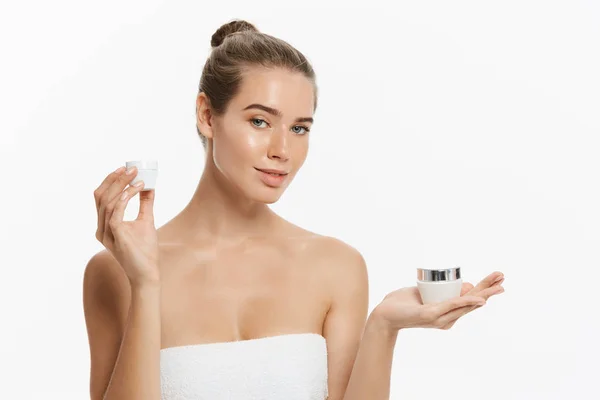 Beauty Youth Skin Care Concept - Beautiful Caucasian Woman Face Portrait memegang dan mempresentasikan produk tabung krim. Beautiful Spa model Girl with Perfect Fresh Clean Skin over white background — Stok Foto