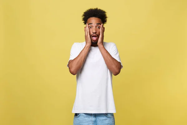 Conceito Emocional e Pessoas - Retrato do jovem afro-americano animado gritando em choque e espanto de mãos dadas na cabeça . — Fotografia de Stock