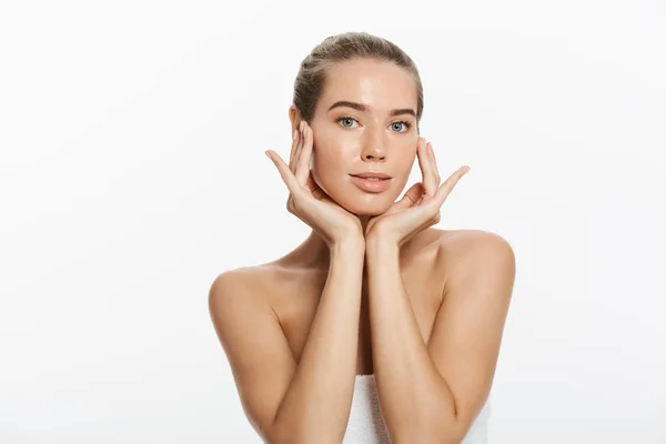 Giovane donna che tocca il suo viso isolato su sfondo bianco — Foto Stock