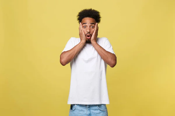 Emotional and People Concept - Portrait of excited young African American man screaming in shock and amazement holding hands on head. — Stock Photo, Image