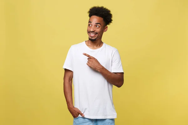 Jovem homem afro-americano bonito sobre fundo amarelo apontando para cima . — Fotografia de Stock