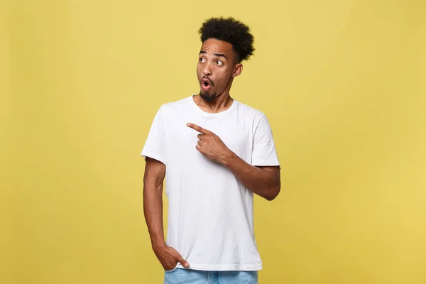 Kapalı fotoğraf genç Afrikalı-Amerikalı adam üzerinde reklam dikkat çekerek, ürünler, uygulamalar veya hizmet tanıtımı beyaz onun boş T-shirt için işaret resimde izole üzerinde gri arka plan. — Stok fotoğraf
