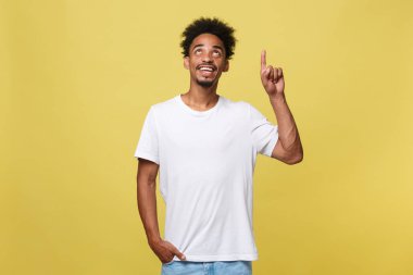 Uzak yan izole sarı arka plan üzerinde parmak ile işaret eden sakallı Afrikalı-Amerikalı adam.