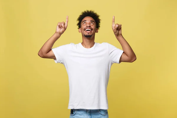 Afrikanisch-amerikanischer Mann mit Bart zeigt Seite mit Finger isoliert über gelbem Hintergrund. — Stockfoto