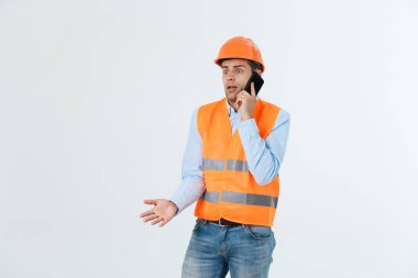 Cep telefonu, site bina işçiler ile iletişim için akıllı telefon kullanan ciddi yetişkin erkek kişi konuşurken inşaat mühendisi.