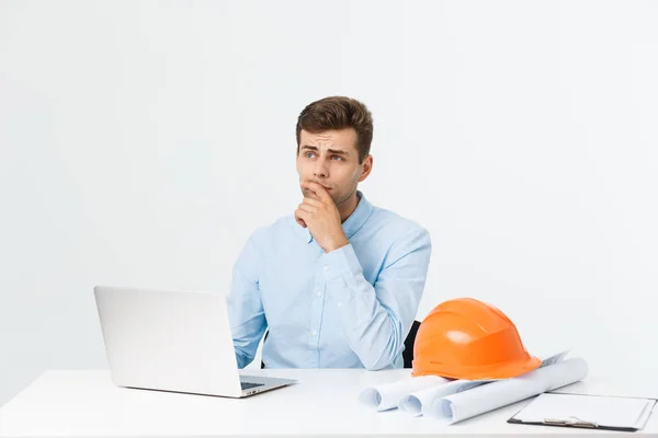 Ingeniero de construcción masculino guapo que trabaja en la oficina con el ordenador portátil — Foto de Stock