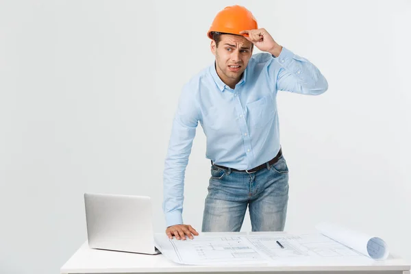 Stressed young constructor having headache or migraine looking exhausted and worried isolated on white background with copy space.