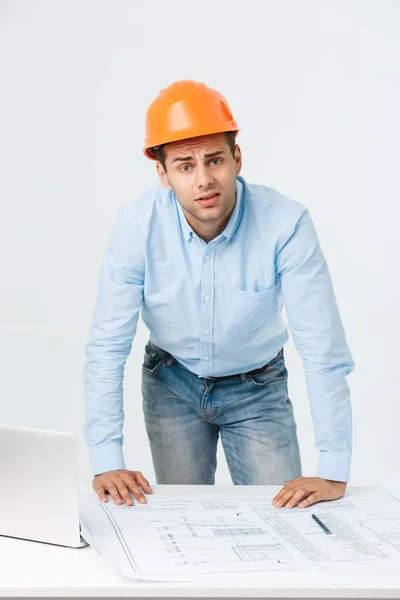 Jonge constructor hebben van hoofdpijn of migraine op zoek uitgeput en ongerust geïsoleerd op witte achtergrond met kopie ruimte benadrukt — Stockfoto