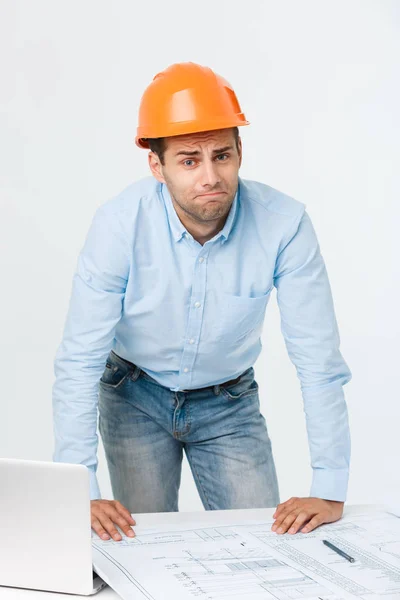 Estressado jovem construtor com dor de cabeça ou enxaqueca olhando exausto e preocupado isolado em fundo branco com espaço de cópia — Fotografia de Stock