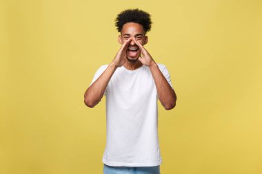 pozitif genç siyah adam, öğrenci, işçi çalışan çığlıklar ağzı geniş açık ve yüzüne ağızlık olarak ellerini koyarak. Portre rahat giyim beyaz arka plan üzerinde.