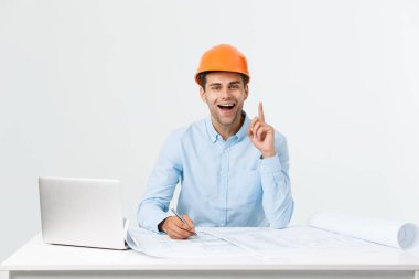 Dizüstü bilgisayar ile ofiste çalışan yakışıklı erkek inşaat mühendisi