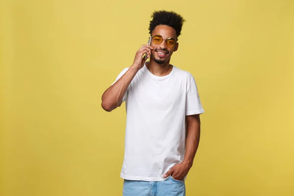 Porträt eines coolen jungen Schwarzen, der mit dem Handy spricht. isoliert auf gelbem Hintergrund — Stockfoto
