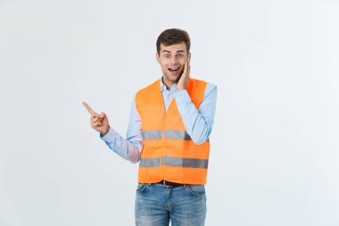 Beyaz arka plan giyen yüklenici üniforma ve kask üzerinde beyaz delikanlı bir fikir ya da soru işaret parmağı gülen yüz, bir numara ile şaşırttı