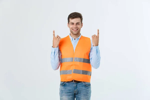 Jeune homme caucasien sur fond blanc portant un uniforme d'entrepreneur et un casque de sécurité surpris par une idée ou une question pointant du doigt avec un visage heureux, numéro un — Photo