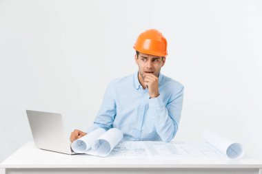 Ciddi adam iş adamı ya da mühendis inşaat alanı içinde oturuyor. Cesur bir orta yaşlı adam üzgün, ciddi ve depresif yüz ifadesi ile oturmak.