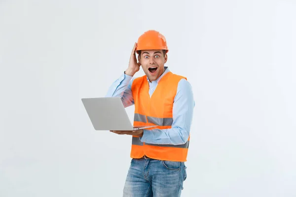 Porträt eines überraschten Ingenieurs, der seinen Laptop über grauen Hintergrund hält. — Stockfoto