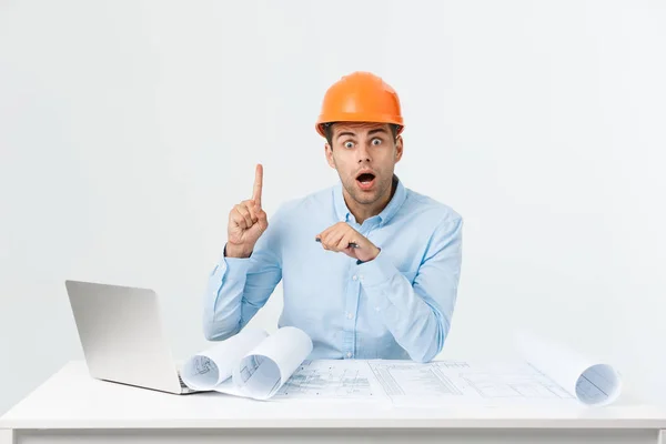 Retrato del joven diseñador de interiores masculino o ingeniero sonriendo mientras está sentado en la mesa de su oficina . — Foto de Stock