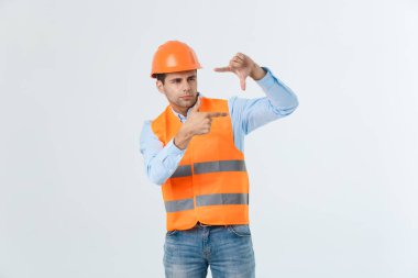Genç yakışıklı architec adam ile çerçeve elleri ve parmakları ile gülen surat yapma izole arka plan üzerinde güvenlik kask giyiyor. Yaratıcılık ve Fotoğrafçılık kavramı.