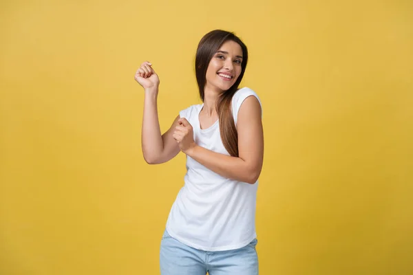 Ritratto di una giovane donna felice che balla su sfondo giallo — Foto Stock