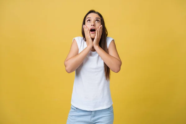 Sorpresa ragazza adolescente mostrano espressione scioccante con qualcosa. Isolato su sfondo giallo brillante. Copia spazio — Foto Stock