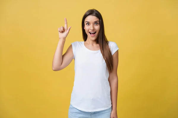 Amaze jovem apontando para um lado com o dedo enquanto abre a boca contra um fundo amarelo — Fotografia de Stock