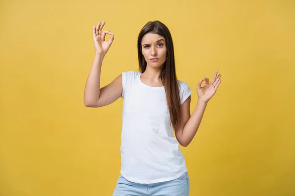 Felice giovane donna mostrando segno ok con le dita un occhiolino isolato su uno sfondo giallo — Foto Stock