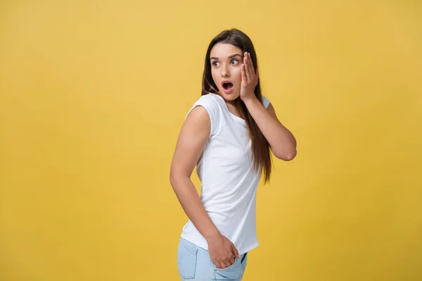 Prachtige vrouwelijke halve lengte portret geïsoleerd op gele studio achtergrondgeluid. De jonge emotionele glimlachend en verrast vrouw permanent en camera te kijken. De menselijke emoties, gelaatsuitdrukking concept — Stockfoto