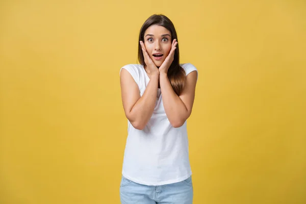 Bellissimo ritratto femminile a mezza lunghezza isolato su backgroud studio giallo. La giovane donna emotiva sorridente e sorpresa in piedi e guardando la macchina fotografica. Le emozioni umane, il concetto di espressione facciale — Foto Stock