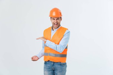 Beyaz arka plan üzerinde el tarafında tutarak ve bir şeyler, caro gömlek ve Sarı yelek ve turuncu kask, kot giyen adam açıklamaya mutlu sakal mühendis izole
