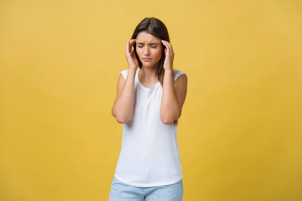 La joven sufre de un dolor de cabeza sobre un fondo amarillo. Captura de estudio —  Fotos de Stock