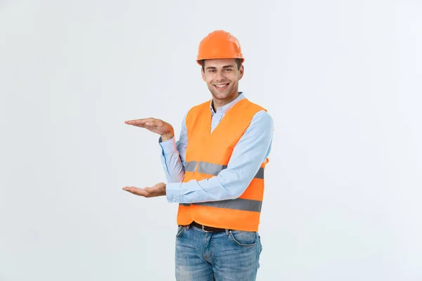 Happy vousy inženýr drží ruku na straně a vysvětlovat něco, chlap na sobě caro košile a džíny s vesta žlutá a oranžová helma, izolované na bílém pozadí — Stock fotografie